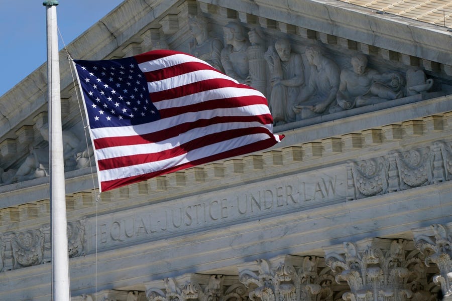 FILE - An American flag waves in front of the Supreme Court building, Nov. 2, 2020, on Capitol Hill in Washington.  A divided Supreme Court has rejected an appeal from a Black Texas death row inmate who argued he didn’t get a fair trial because jurors who convicted him objected to interracial marriage. The court’s three liberal justices dissented Tuesday from the court’s order turning away the appeal from inmate Andre Thomas. He was sentenced to death for killing his estranged wife,
 who was white, and two children.  (AP Photo/Patrick Semansky, File) ORG XMIT: WX203