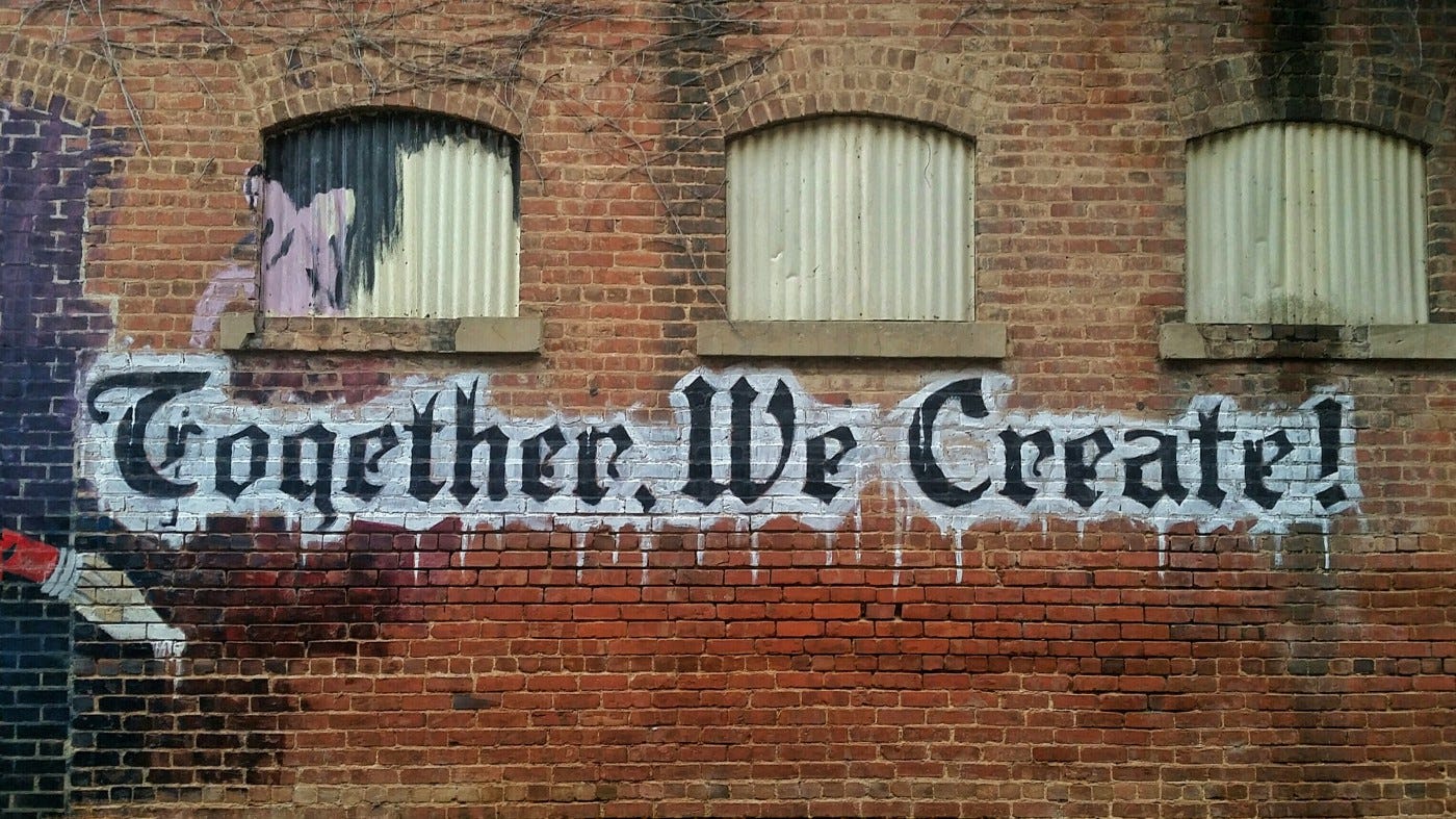Writing on the wall, “Together, We Create!”