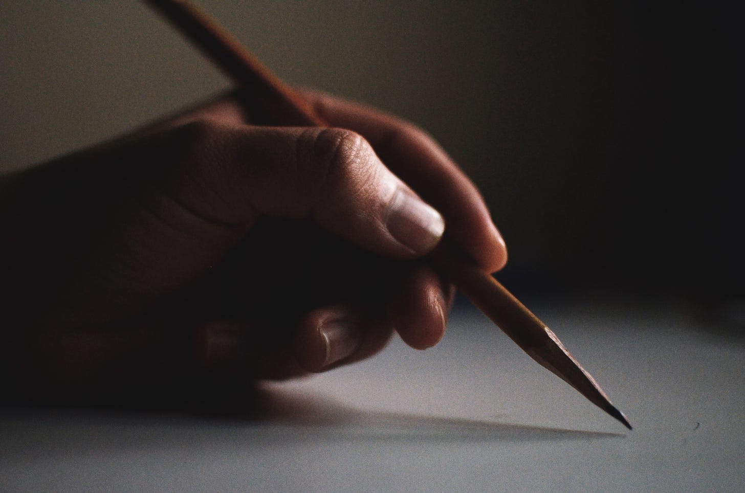 mão segurando um lápis de escrever