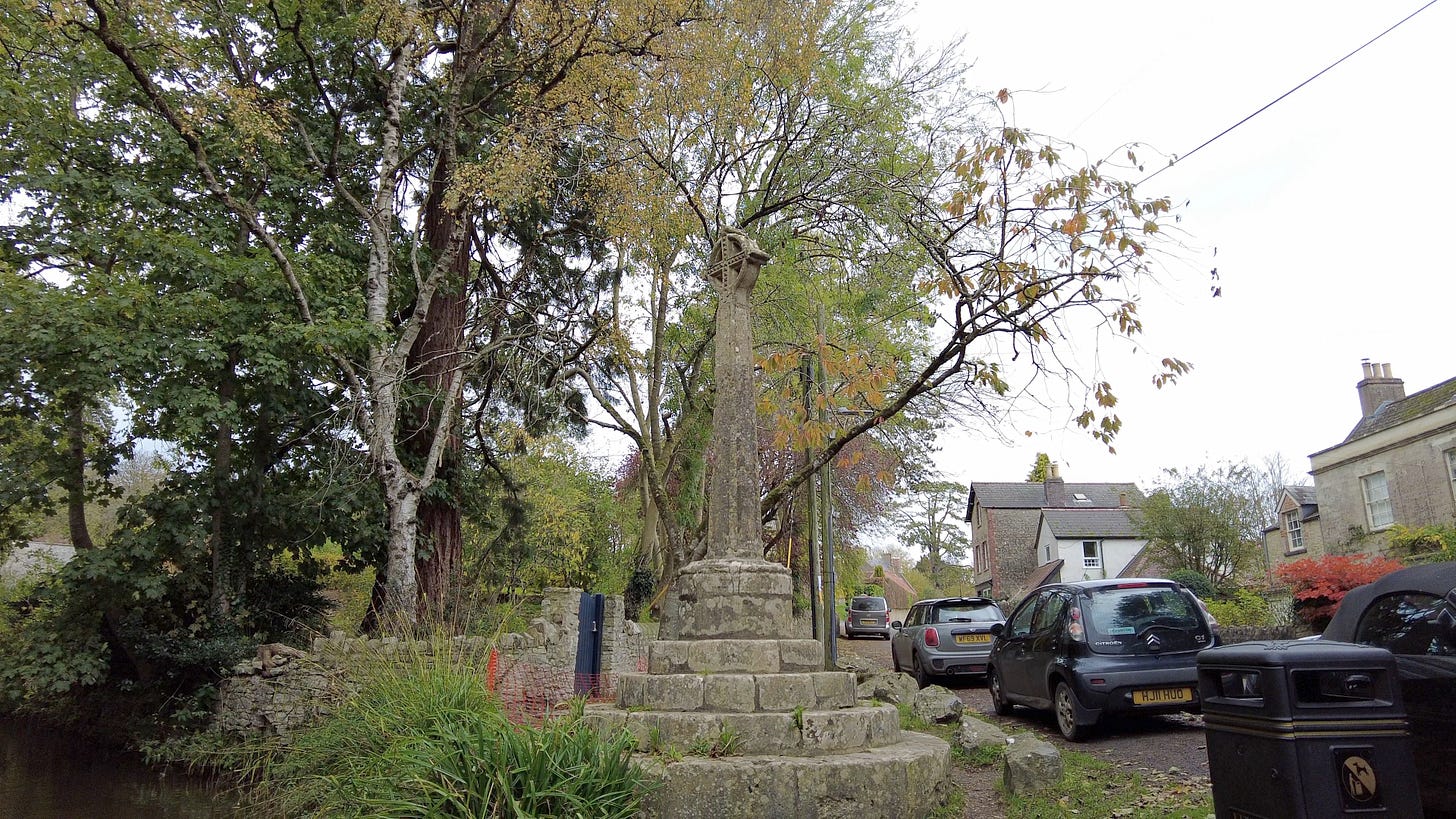 Nunney Market Cross nestled by Nunney Brook.