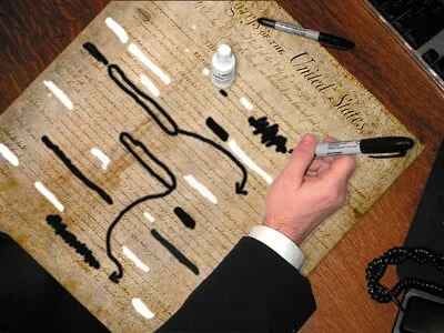 Photo of the Bill of Rights with George W. Bush using a Sharpie and white-out to edit it