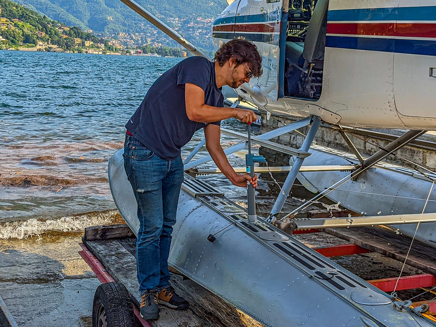 Javier using a handpump to drain water from one of the plane's pontoons. 