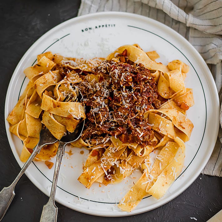 Beef short rib ragu with pappardelle pasta on a white plate