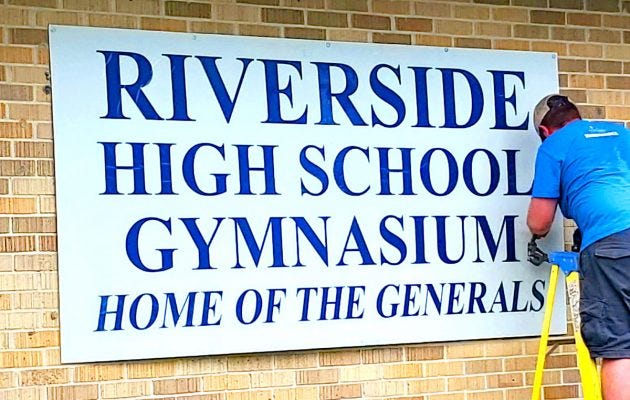 A district employee changes the school sign at Riverside High School, formerly Robert E. Lee High School. August 2, 2021. Accessed via Resident News.