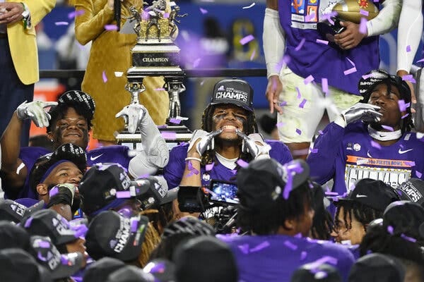 T.C.U. players celebrating with the Fiesta Bowl trophy and confetti falling.