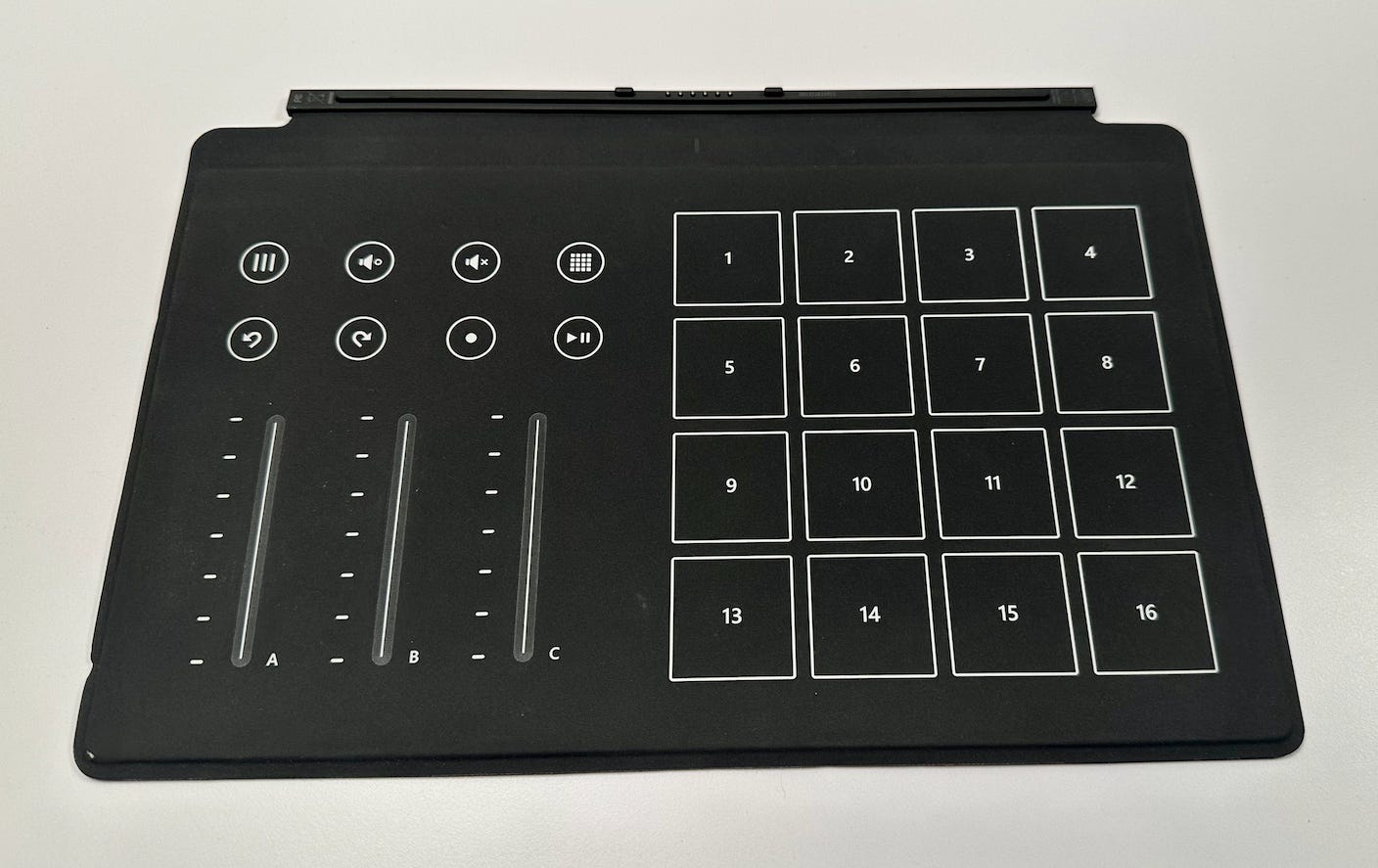 A touch cover with keys printed for being a drum machine rather than typing letters. There are giant numbers, volume and tracking controls and sliders.