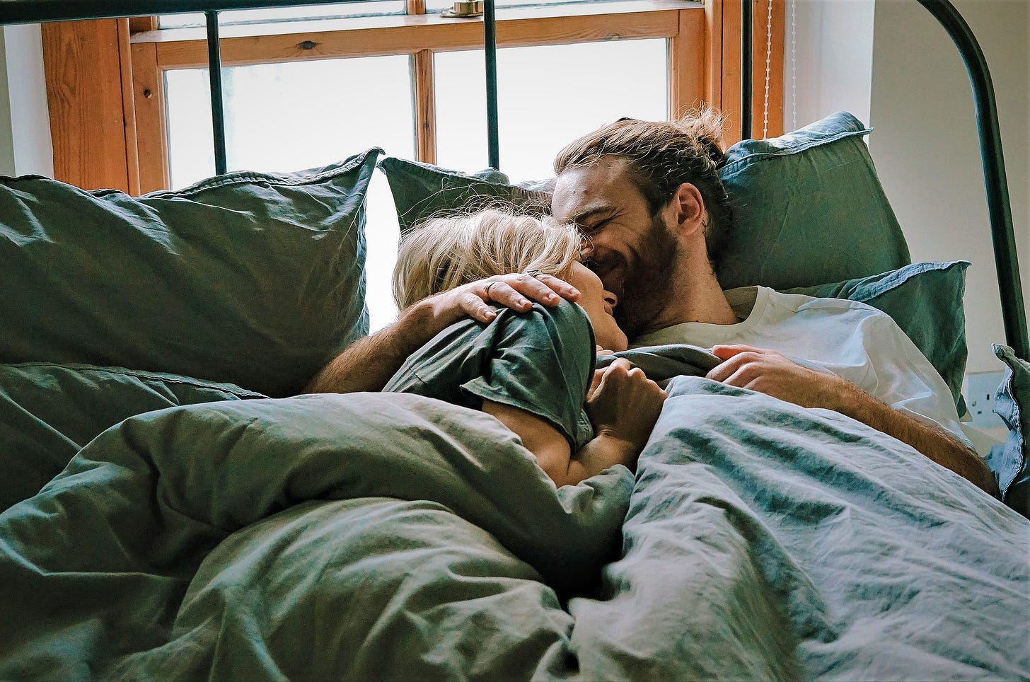 happy couple cuddling in bed happy couple cuddling in bed