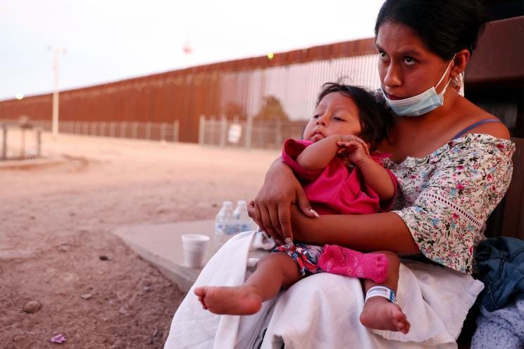 An immigrant mother holds her one-year-old son