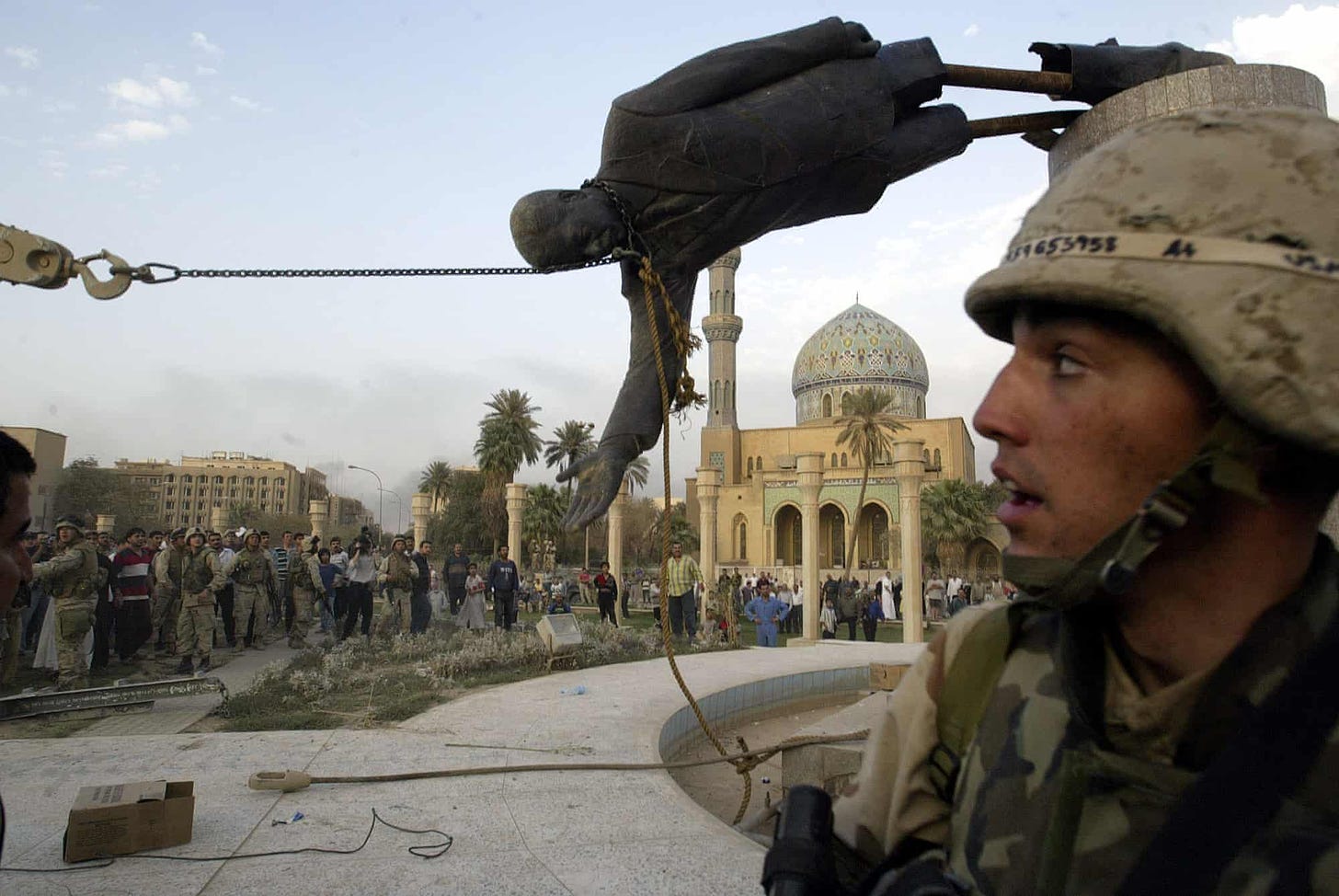 9 April 2003 Three weeks into the US-led invasion of Iraq, American soldiers and Iraqi civilians pull down a statue of Saddam Hussein in downtown Baghdad. Photograph: Jérôme Delay/AP