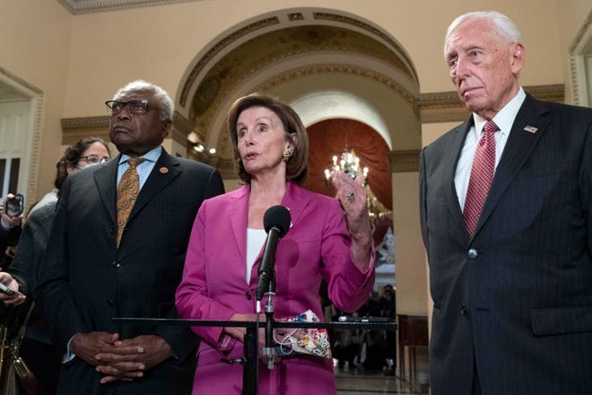 House Speaker Nancy Pelosi, D-Calif., accompanied by House Majority Whip James Clyburn, D-S.C., left and House Majority Leader Steny Hoyer D-MD, speaks to reporters at the Capitol in Washington, Friday, before the House passed an historic infrastructure bill.