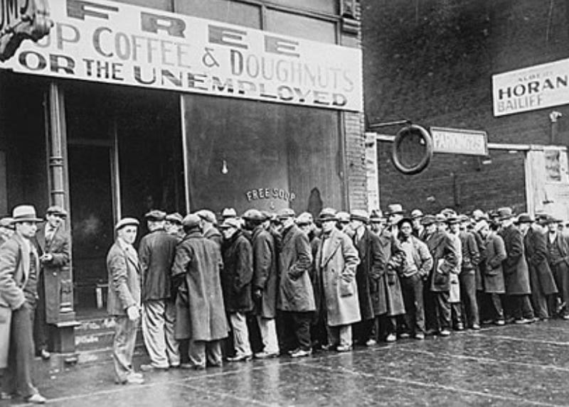 Photo of Great Depression breadline. A long line of men standing outside, wearing tattered coats.