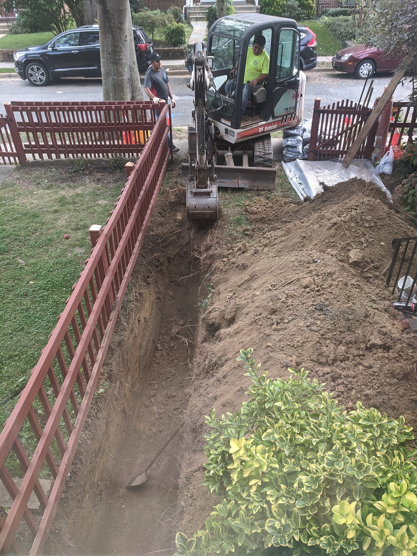 Workers dig a trench in my front yard, obliterating my lawn.