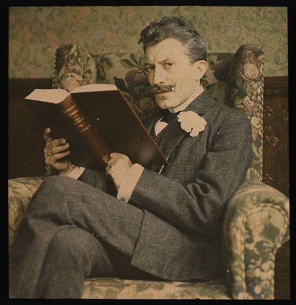 File:Man with book sitting in chair (2677422743).jpg