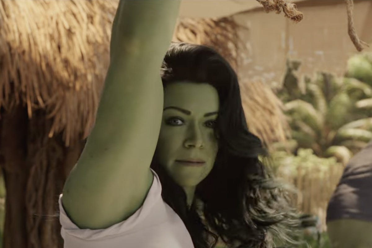 jennifer walters with her arm up while in she hulk form, with hulk behind her