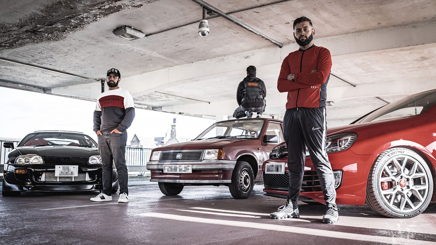 Three Bradford youths of Pakistani origin stand next to their souped-up cars.