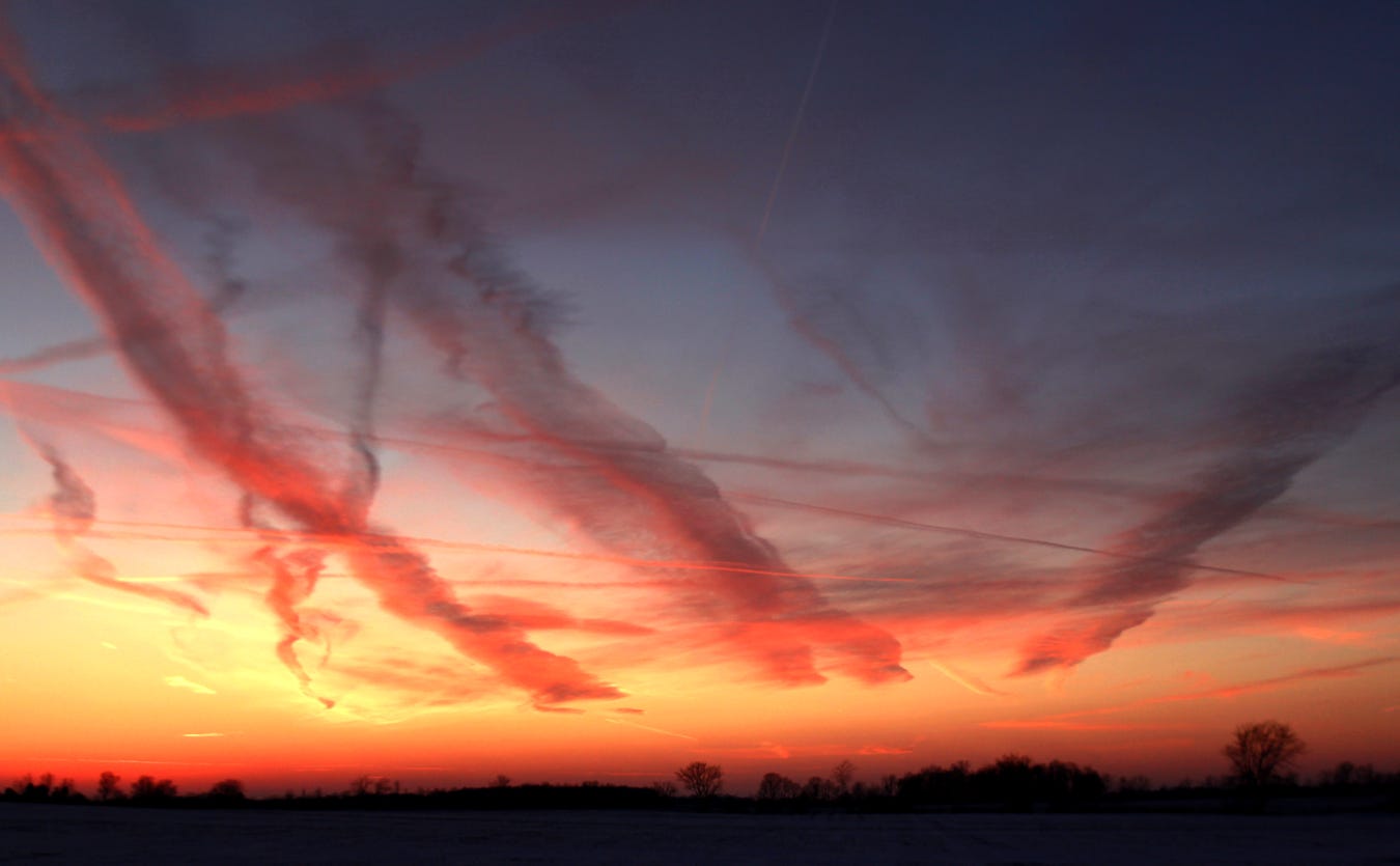 Deep cold isn’t good for much, but a combination of freezing temperatures and low humidity create crystalline skies. In such conditions, inhospitable though they may be, jet contrails sometimes look surreal, here painting up a sunset like a wild-eyed watercolorist.