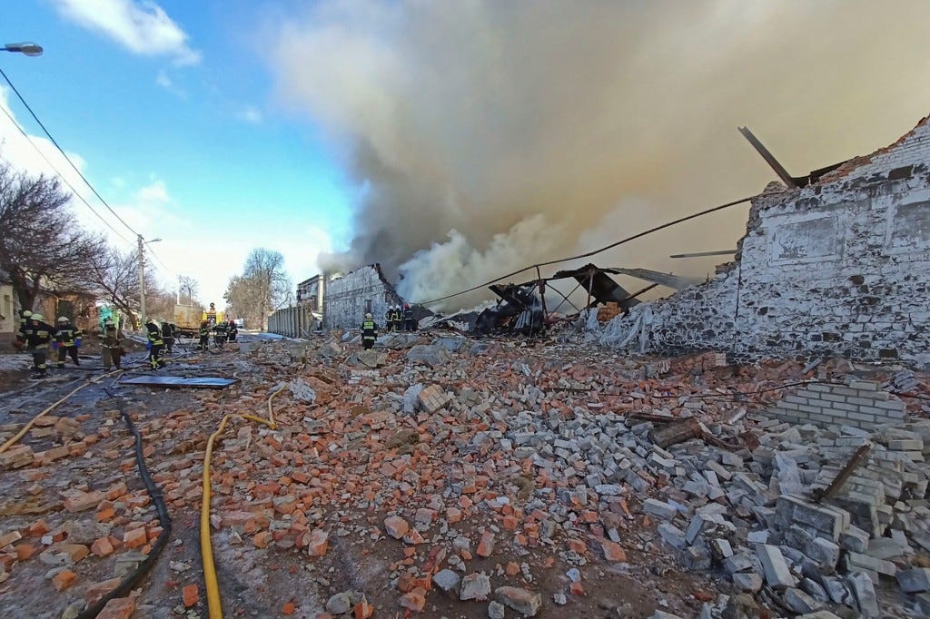 Rescuers work at a site of a warehouse storing products burned after shelling,