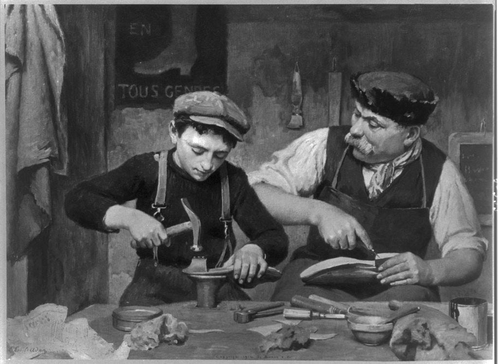 A photo of a man and a boy making shoes together.