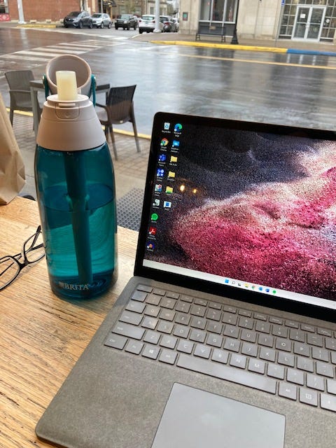 Robyn's laptop sitting in a coffee shop window looking out onto a rainy street in downtown Madison