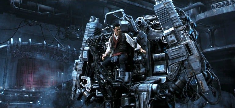 image from The Matrix: Revolutions showing a human sitting in a large tank-like machine that has no cockpit so the human is very exposed