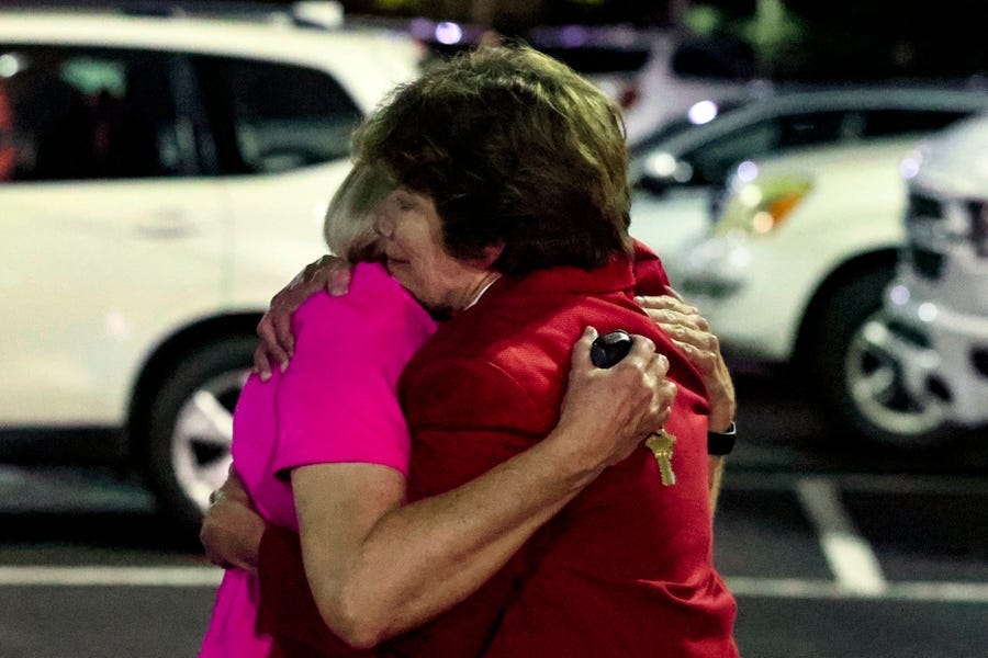 Church members console each other after a shooting at the Saint Stevens Episcopal Church in Vestavia, Alabama.