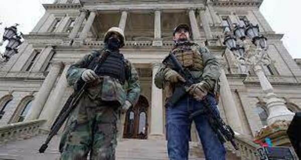 Armed men stand on the steps at the State Capitol after a rally in support of President Trump in Lansing, Michigan, on Jan. 6, 2021. (Paul Sancya/AP)