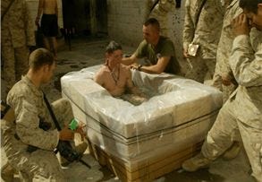 Falluja, Iraq--Sgt. Andrew Jones, 25, of Sullivan, In., is baptized by Navy Chaplain Scott Radetski during a ceremony held at a Marine base of operations in Falluja, Iraq. "To me, this is a good place to be reborn out here because we have lost some many friends. In this school alone we have lost two good Marines and then two days ago we lost another one," says Jones citing the reasons he came to be baptized in Iraq while fighting with insurgents. (Los Angeles Times)