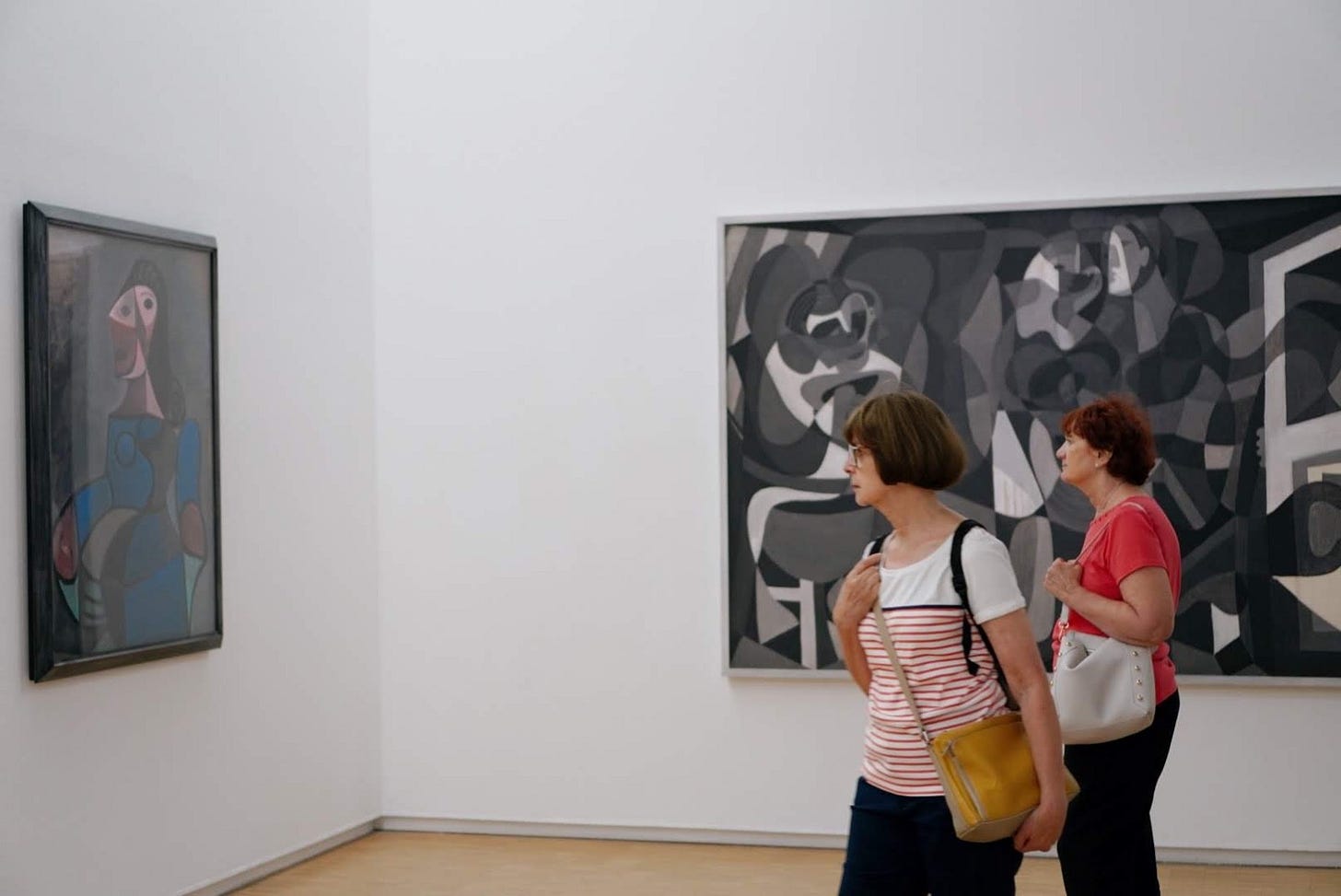 Picture of two people looking at a Picasso painting in a museum.
