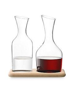 From the Wine Collection. Mouthblown glass carafes for water and wine, set atop an oak base..Includes: 2 carafes, and 1 base.Water carafe: 40.6 oz capacity.Wine carafe: 47.3 oz capacity.Base: 6.1"W x 10.8"L.Handmade glass/oak.Hand wash.Imported.
