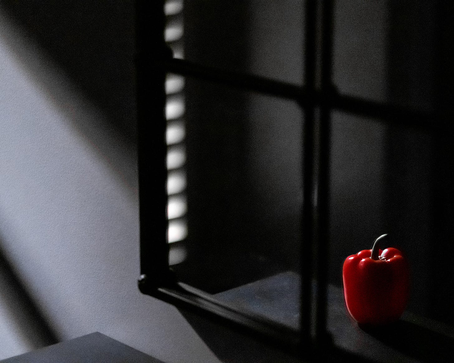 A red pepper resting on an entryway table is reflected in a mirror. 
