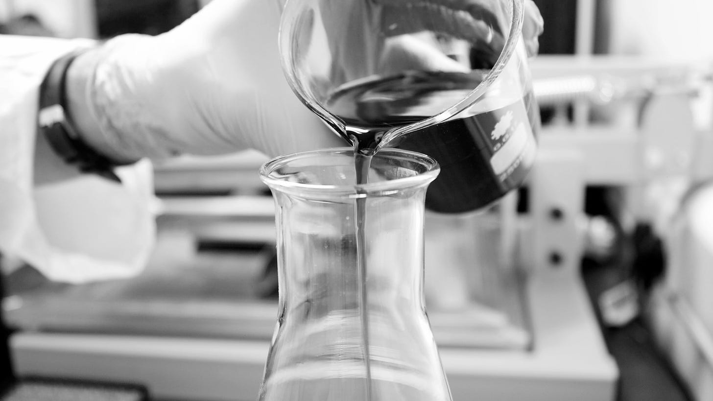 Liquid is poured from one beaker into another in a laboratory