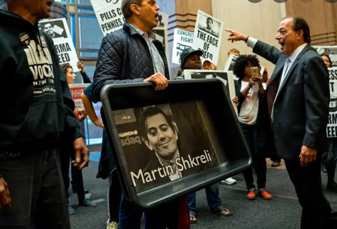 Protestors hold signs and cat litter pans with Martin Shkreli's face on them after the Daraprim price hike in 2015. (Getty Images)
