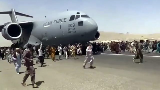 Emberek százai futnak az amerikai légierő C-17-es szállítógépe mellett, amint az a nemzetközi repülőtér kifutópályáján halad lefelé Kabulban, Afganisztánban.