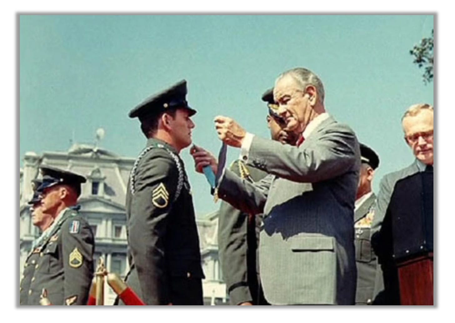 Ken Stumpf stands at attention as LBJ hangs a Medal of Honor around his neck.