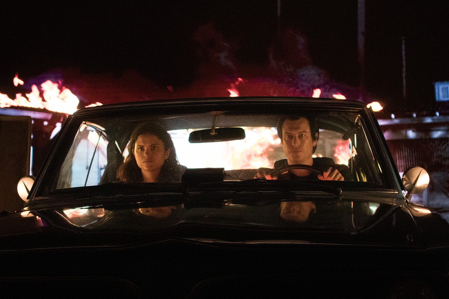 Film still from BLOOD RELATIVES with Victoria Moroles as Jane and Noah Segan as Francis sitting in the front seat of his Barracuda.