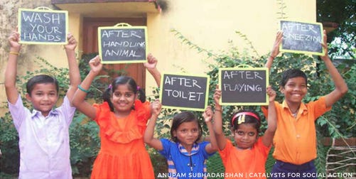 Photo of five children holding signs saying wash your hands, after touching animals etc.