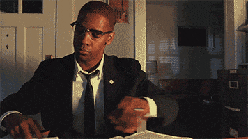 This GIF (repeated moving image) shows Malcolm X (played by Denzel Washington) slamming a tabletop and removing his glasses in anger and frustration. This GIF (repeated moving image) shows Malcolm X (played by Denzel Washington) slamming a tabletop and removing his glasses in anger and frustration.