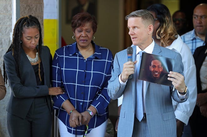 Attorney Bobby DiCello, right, holds up a photograph of Jayland Walker as Paige White, left, comforts Jayland's mother Pamela Walker during a press conference at St. Ashworth Temple on Thursday.