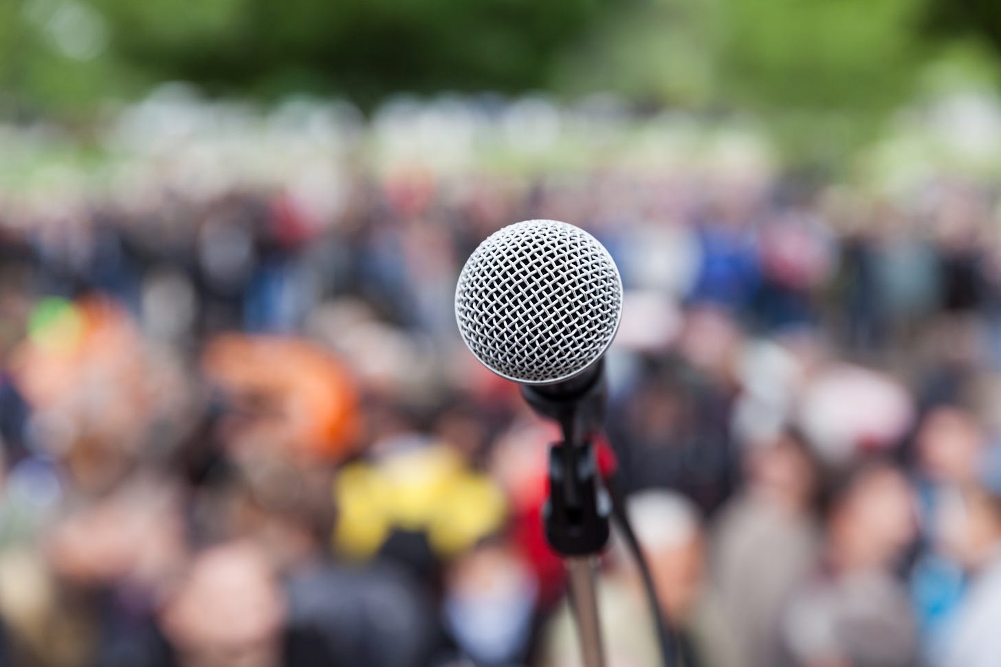 Microphone in focus against blurred crowd. Protest. - New England Literacy  Resource Center