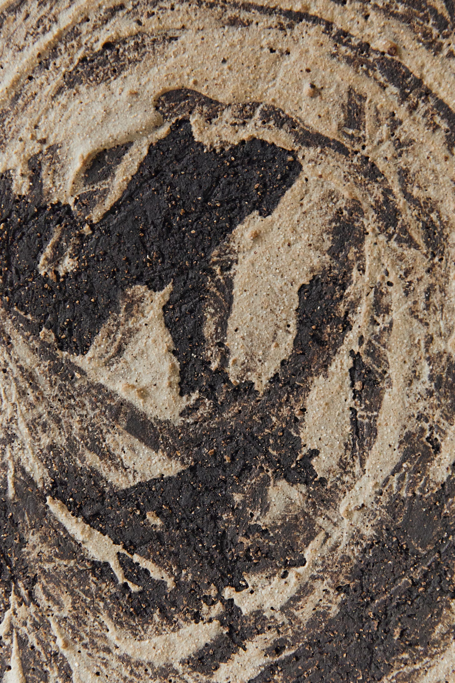 A close-up texture of clay with brushstrokes and grit.