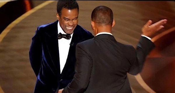 Will Smith, right, smacks comedian Chris Rock in his face during the live broadcast of the Oscars on Sunday, March 27, 2022. (Twitter)