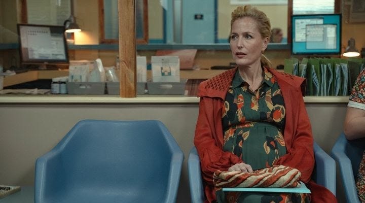 Gillian Anderson's character, pregant and seated, in Sex Education