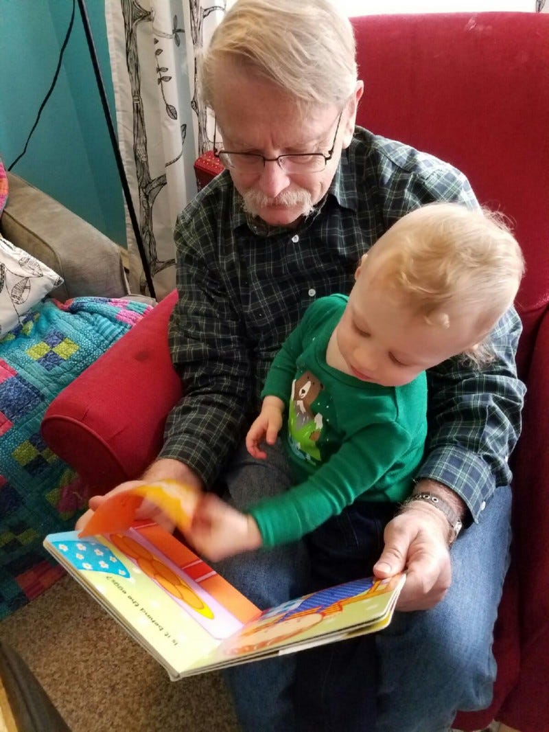 Writer with honorary grandson and book.