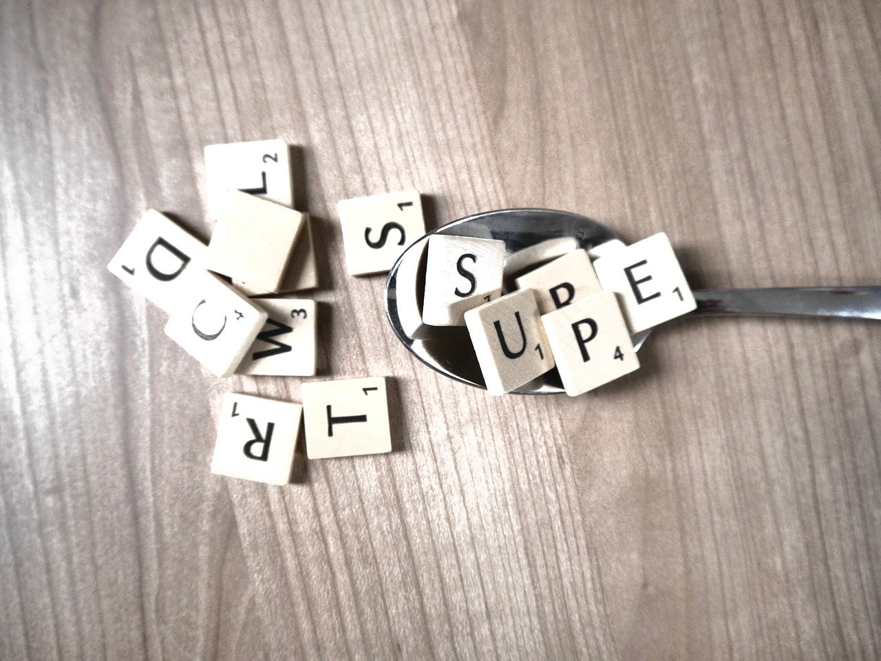 scrabble tiles on spoon and countertop