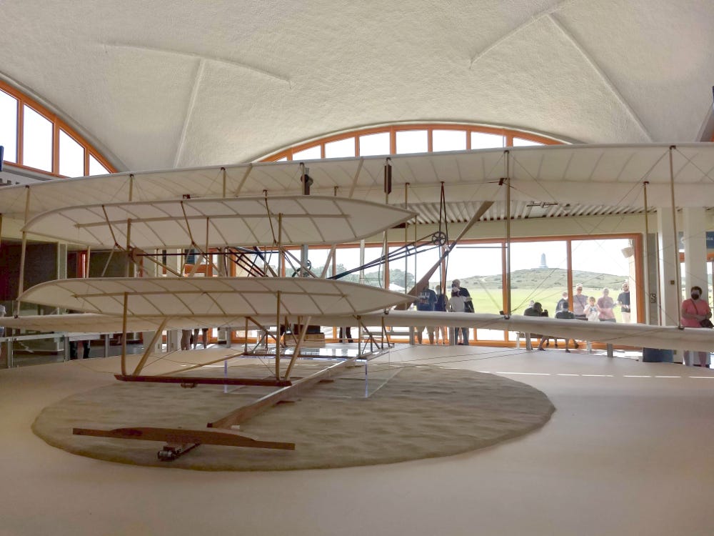 A photo from inside the Wright Brothers Memorial Museum, with a view of the back of the reconstruction of the Wright Flyer