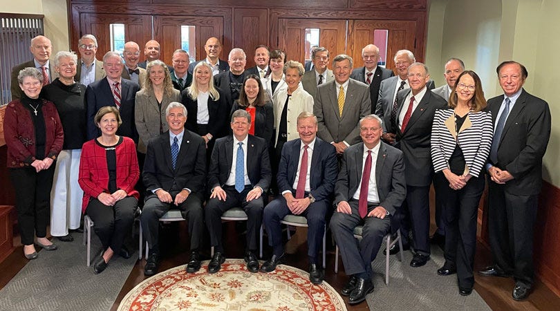 Color photo of Board of Trustees members at Grove City College; some standing, some sitting