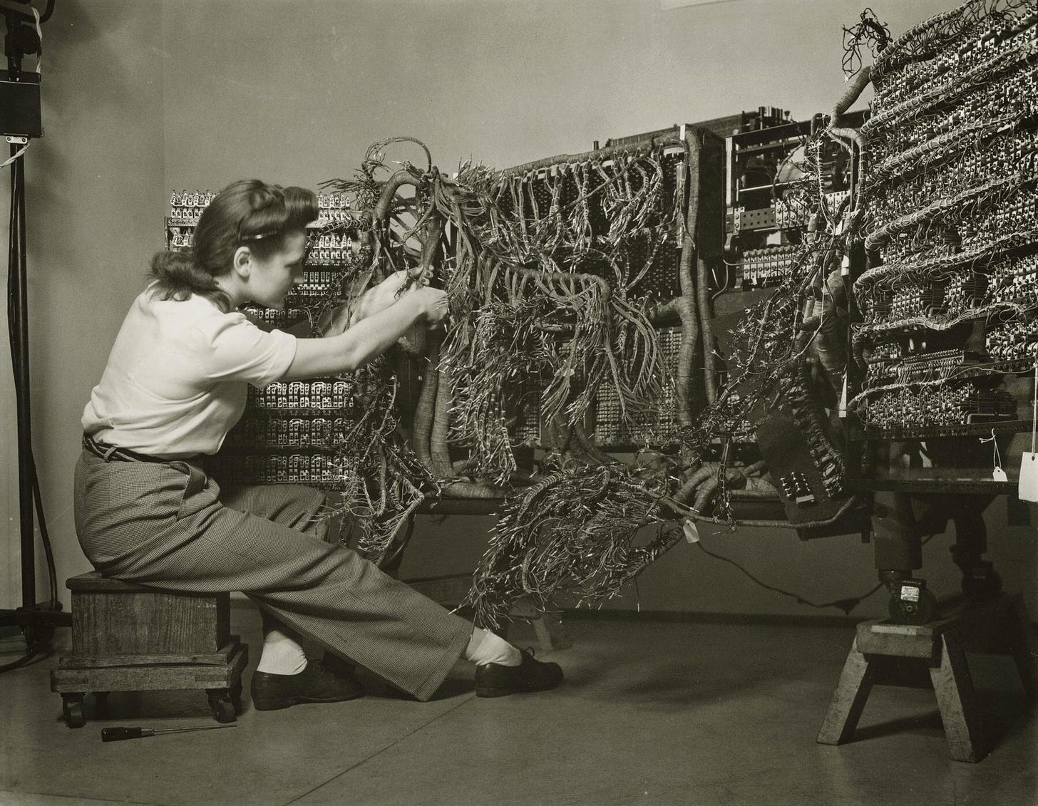 An engineer wiring an early IBM computer, 1958. Photo by Berenice Abbott