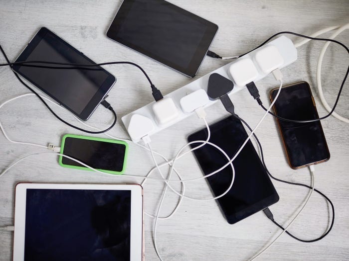 Five mobile devices charging connected to a power chord