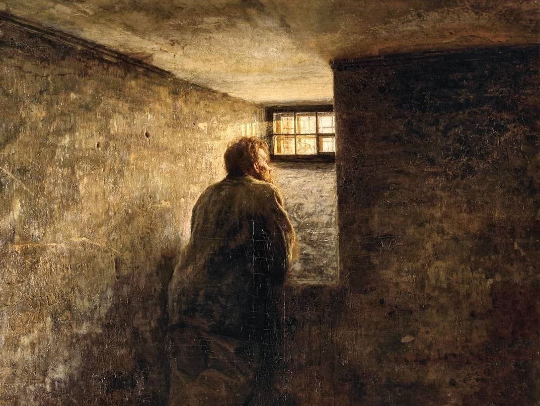 A prisoner looks out of his cell window.
