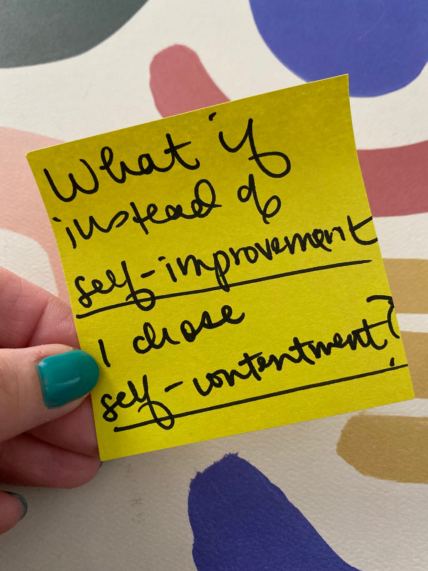 Erin holding up a yellow post it note with today's inspiration written, against a colorful background and teal nails